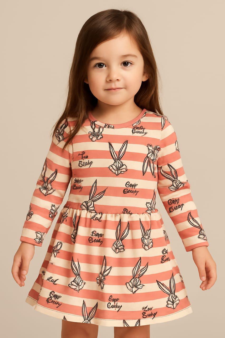 Little girl modeling a long-sleeve dress with horizontal pink and white stripes and black printed graphics of Bugs Bunny and "Bugs Bunny" text.