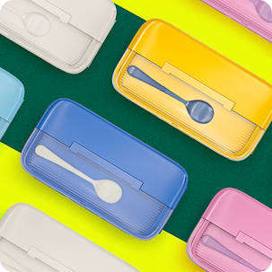 Colorful, stackable kids lunch boxes in yellow, blue, white, and pink, featuring built-in spoon storage on the lids. Text overlay reads Kids Lunch Boxes.