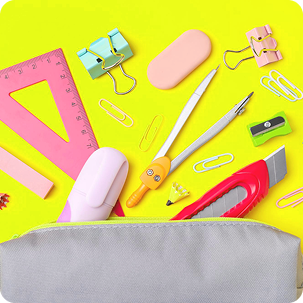 A close-up flat lay of colorful school stationery items, including a compass, erasers, paper clips, and a pink ruler, set against a bright yellow background. Text at the bottom reads Kids Stationeries.